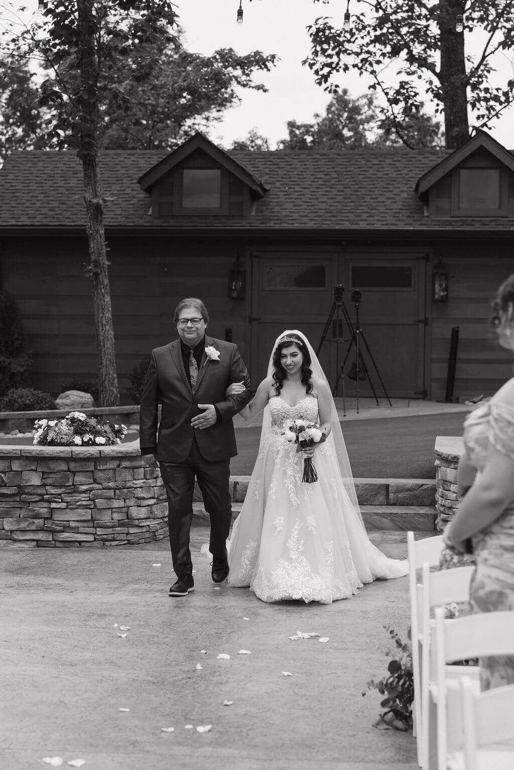 Black-and-white photo of the bride walking down the aisle with her father at The Magnolia.