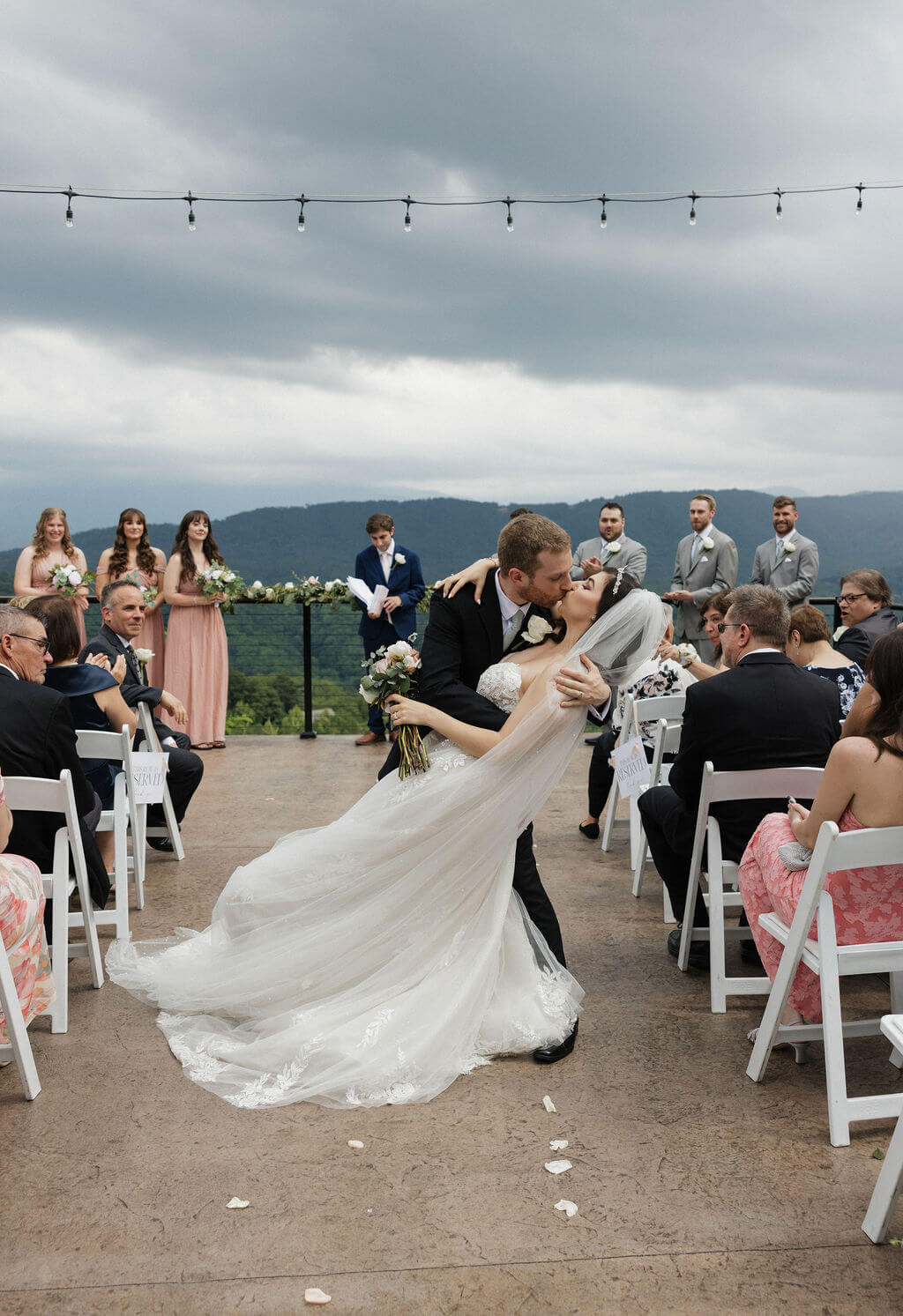 Newlyweds sharing a dip kiss while walking back down the aisle after their ceremony.rr