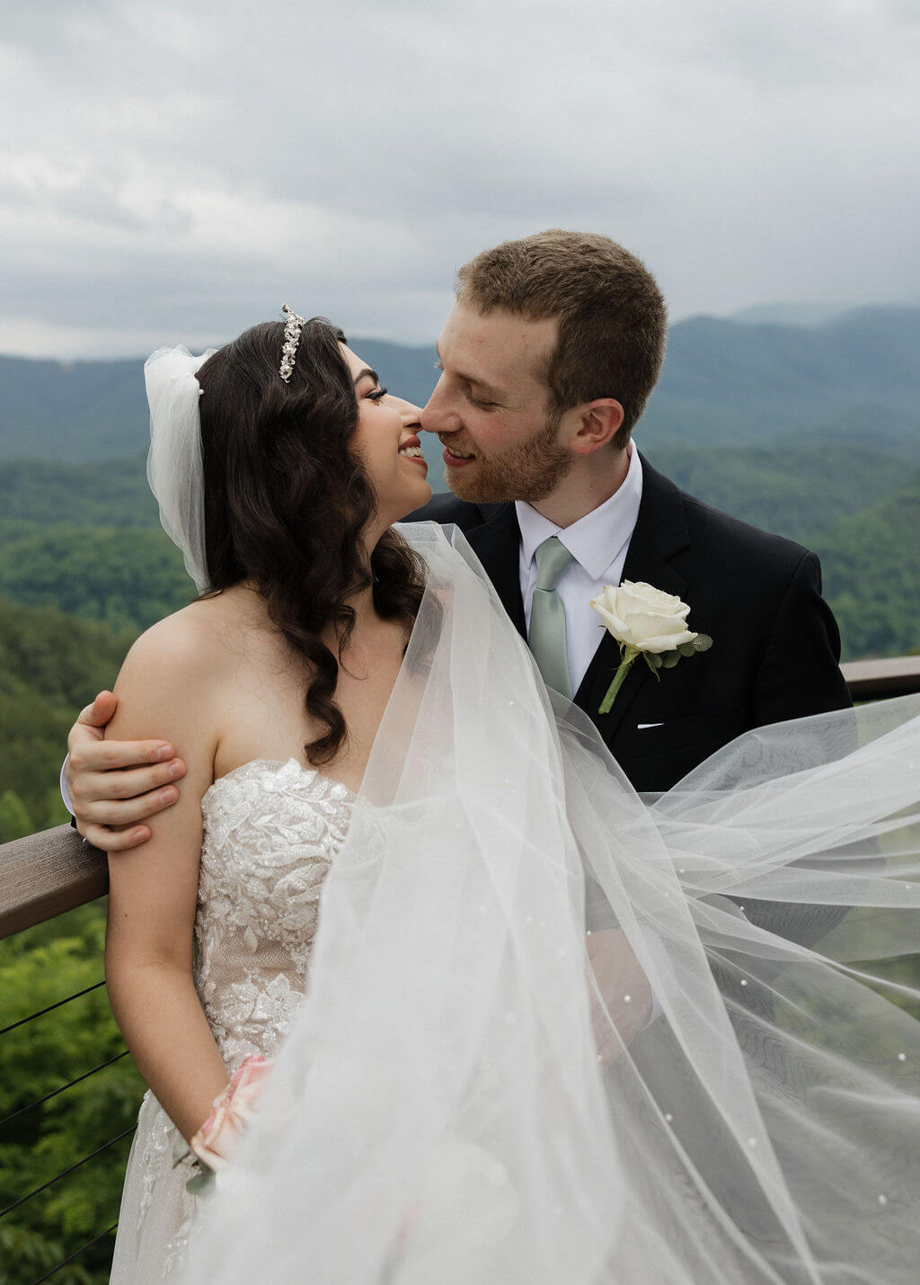 Bride and groom smiling together after their ceremony with the Smoky Mountains in the background.