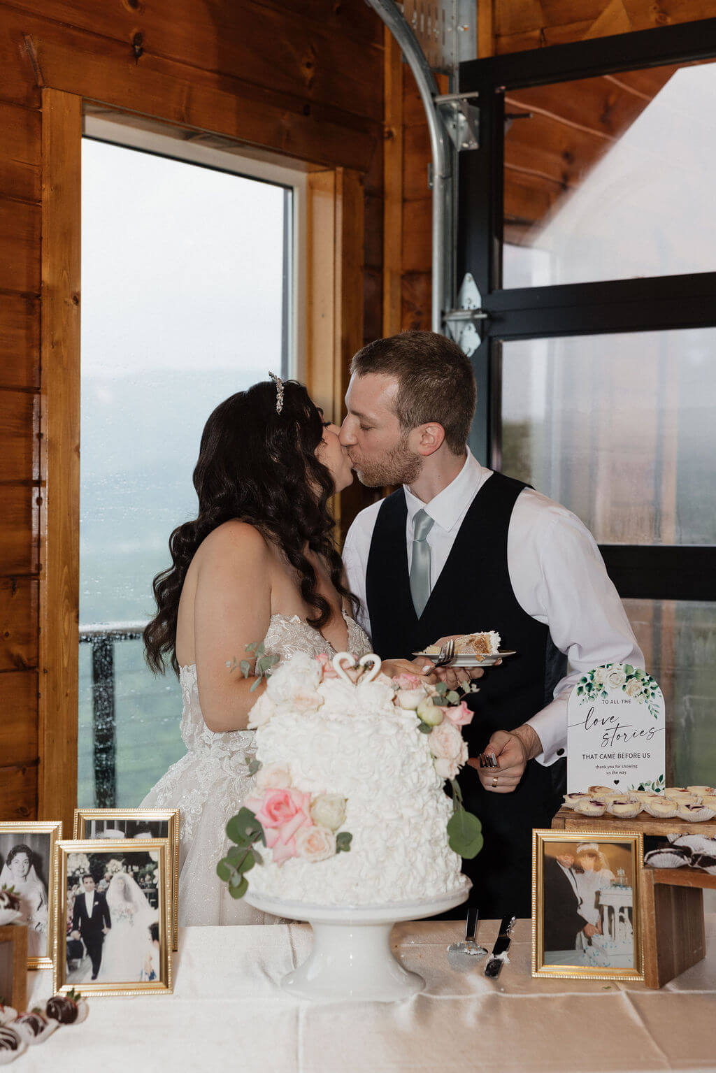 Bride and groom sharing a kiss while cutting their wedding cake during their reception at The Magnolia.