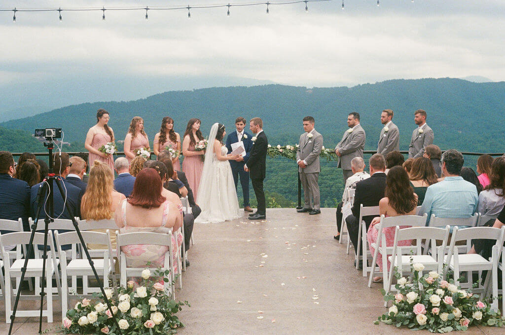 Bride and groom exchange vows during an outdoor wedding ceremony overlooking the Blue Ridge Mountains.