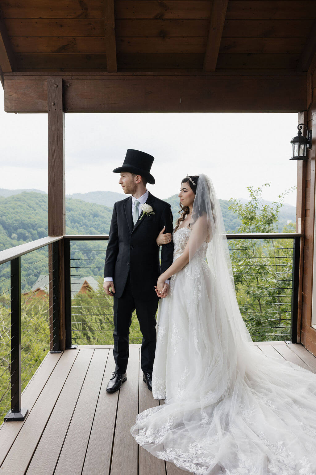 Bride and groom standing together on The Magnolia balcony overlooking the Smoky Mountains.