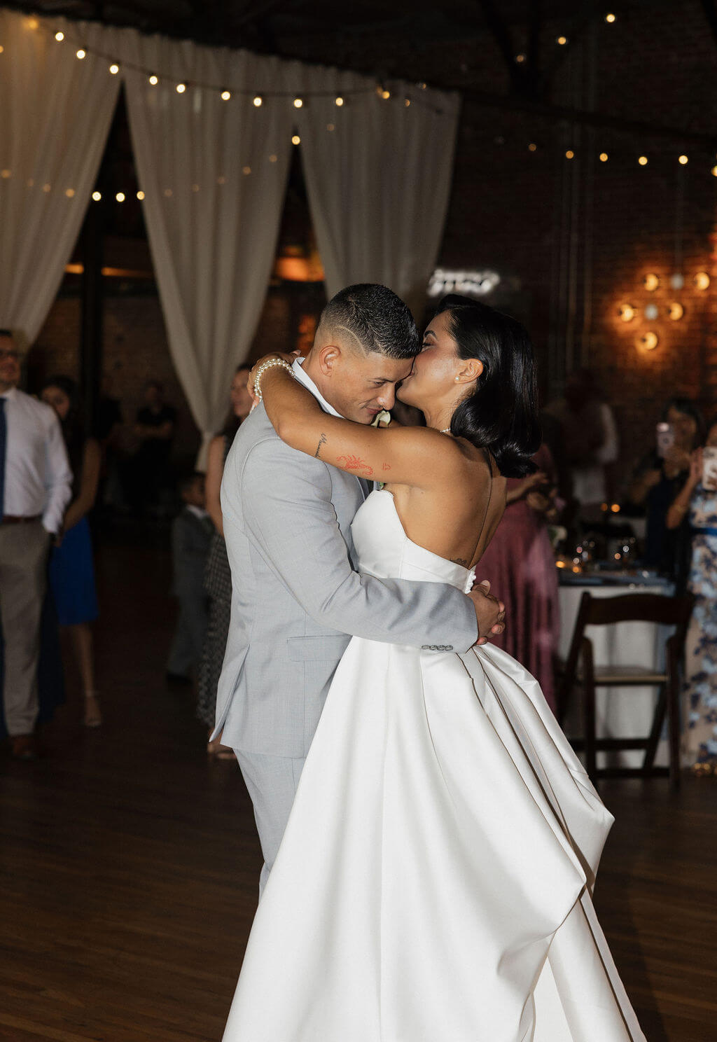 Bride and groom embracing during their first dance at their Mill and Mine wedding reception.
