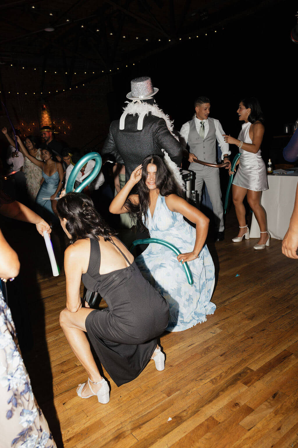 Costumed Hora Loca performer dancing with wedding guests on the reception dance floor.