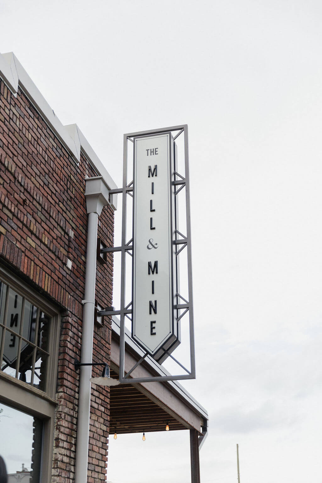 Exterior view of The Mill and Mine sign mounted on the brick wedding venue in downtown Knoxville.