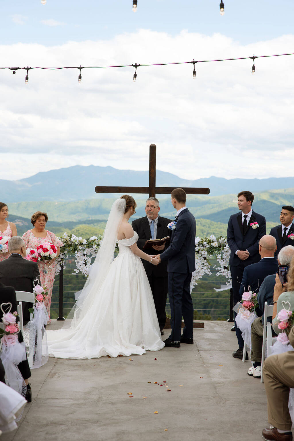 Bride and groom exchange vows during an outdoor wedding ceremony overlooking the Smoky Mountains.