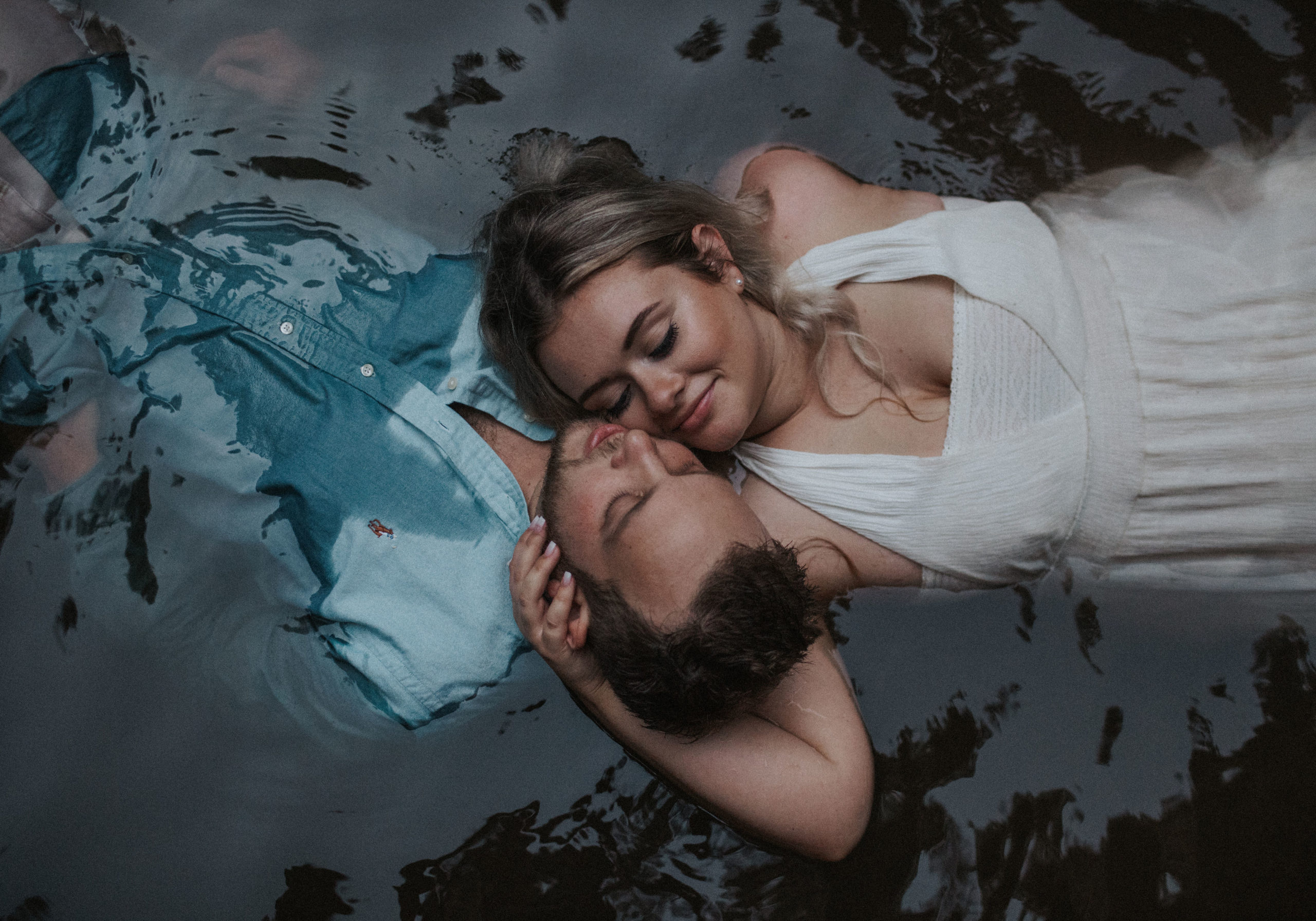 Couple floating in water in a warm embrace